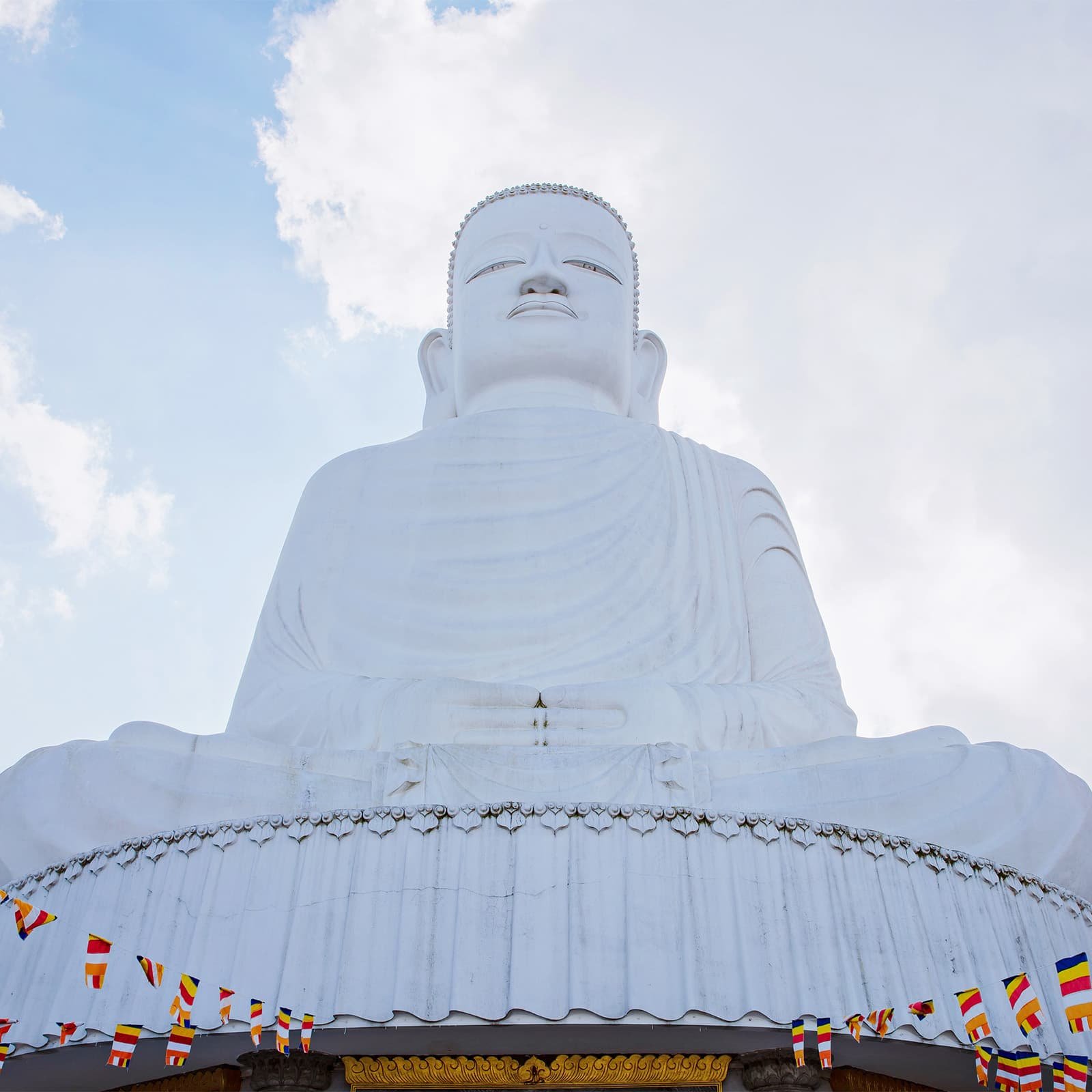 Белоснежная статуя Будды Шакьямуни в пагоде Линь Унг на Ба На Хиллс: спокойное храмовое пространство, контрастирующее с шумными зонами развлечений парка.