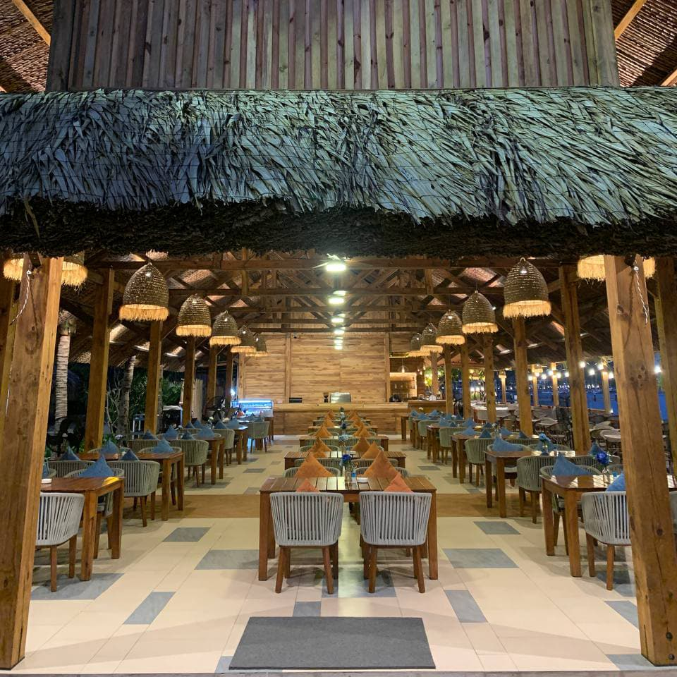 Marina Beach Club Nha Trang вечером — мягкий свет, голубая вода в бухте, подсветка, бар у моря и спокойный пляжный отдых на севере города