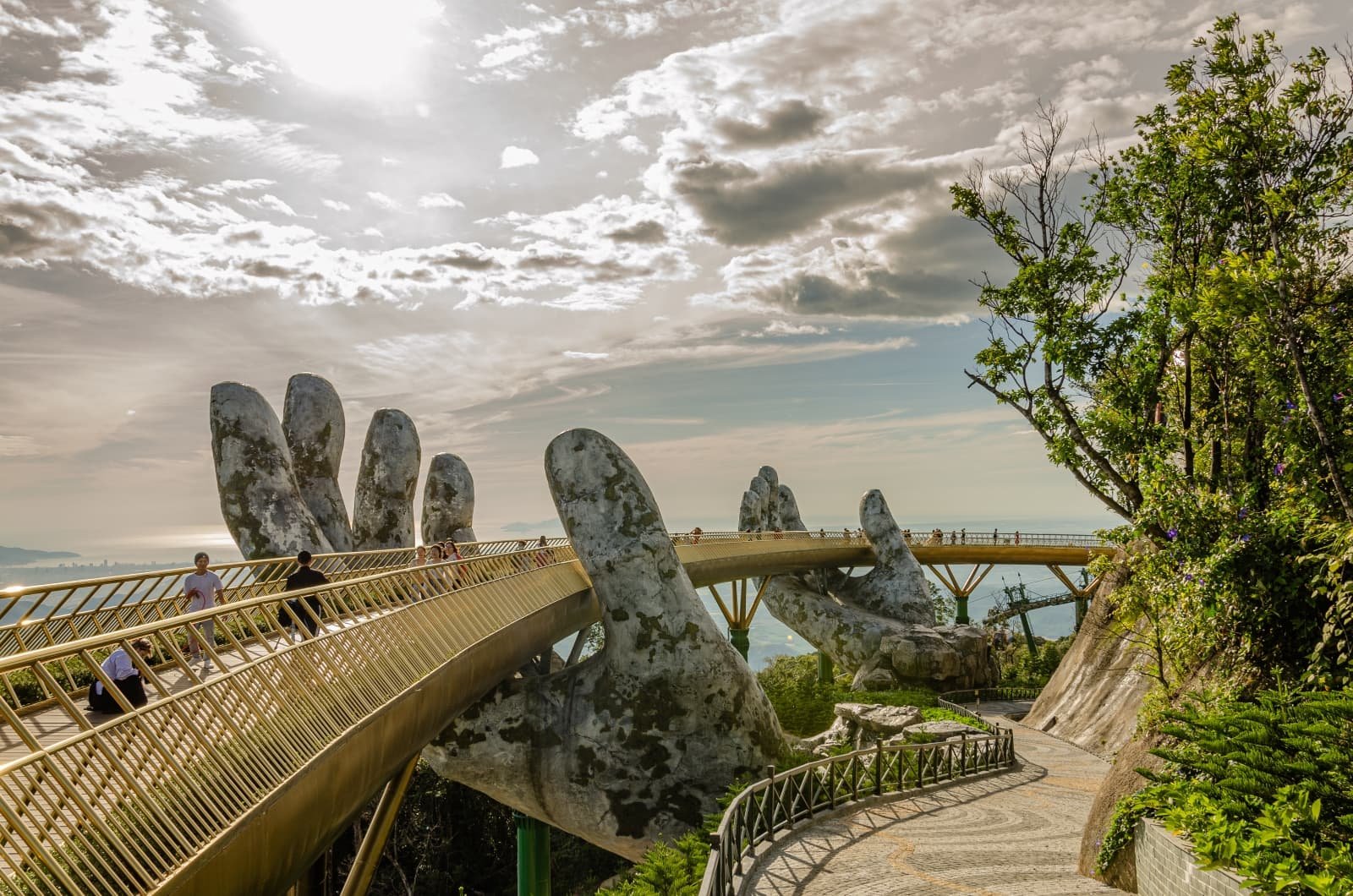 Золотой мост в Ba Na Hills (Дананг): пешеходный мост около 150 м в форме золотой ленты, поддерживаемой двумя гигантскими руками; смотровая площадка над горами и облаками. Экскурсия TianaTours из Нячанга.