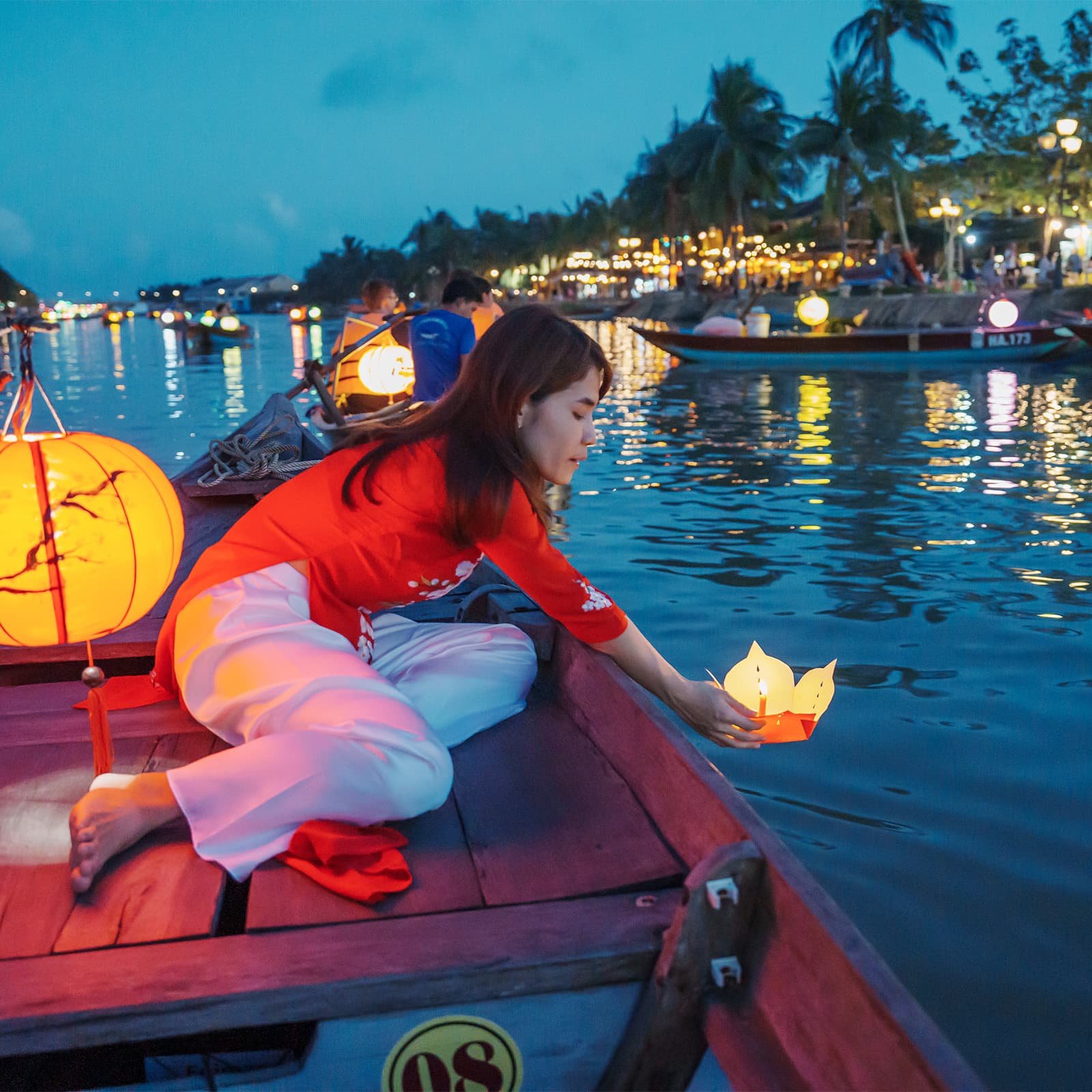 Один из главных ритуалов вечера — запуск бумажных фонариков по реке Тхубон: это тихий, созерцательный жест, который собирает людей на набережных и делает реку частью праздника.