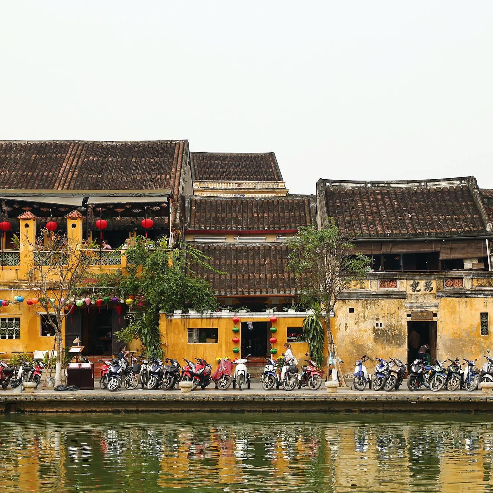 Вечером Хойан меняется за счёт света фонарей над улицами, мостами и лодками на Тхубон — мягкое сияние подчёркивает фактуру стен, балконов и старых ставней.