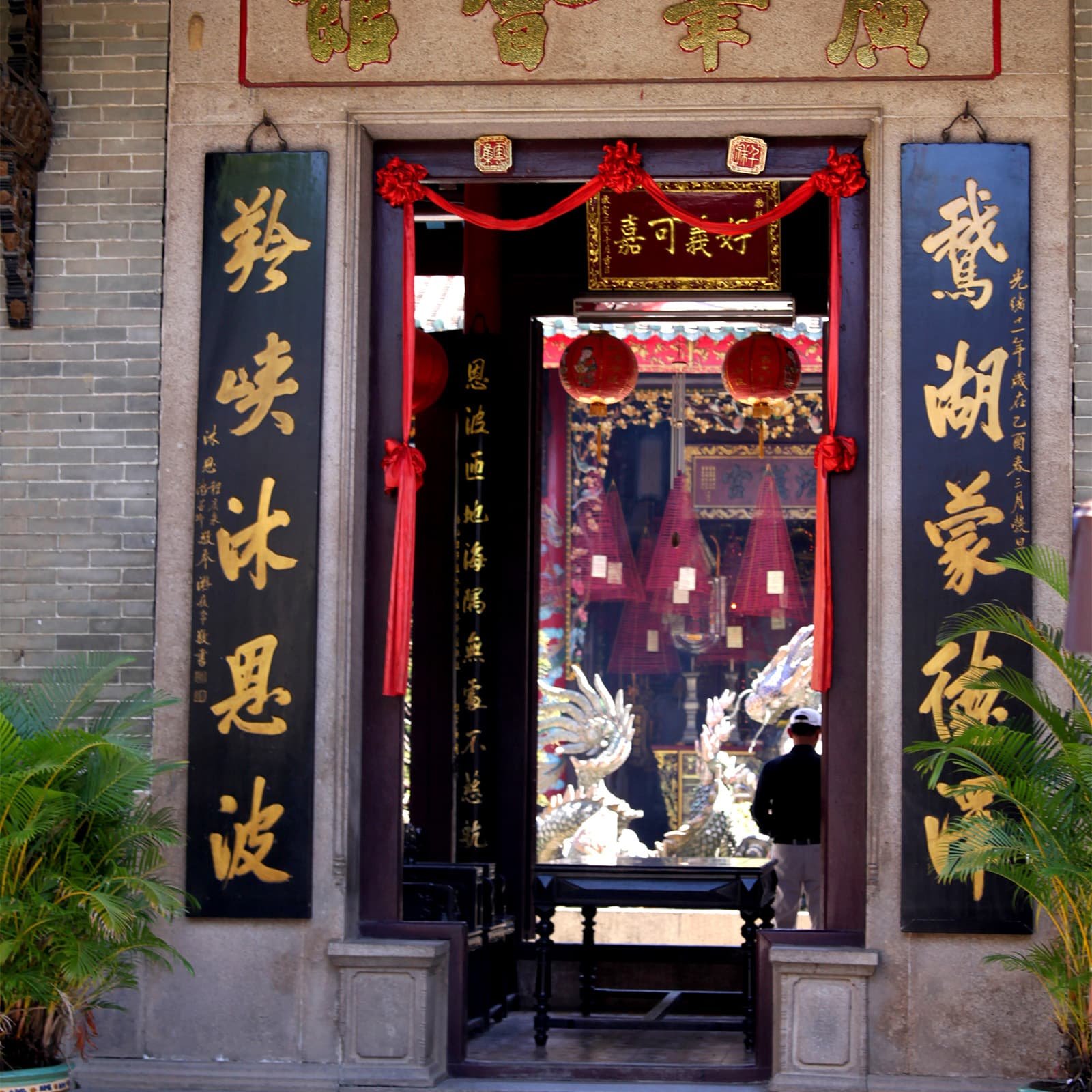 Входная группа Кантонского храма выделяется богато украшенными воротами и ощущением «парадного» ансамбля: за ними открывается внутренний двор со скульптурными деталями и храмовыми постройками.