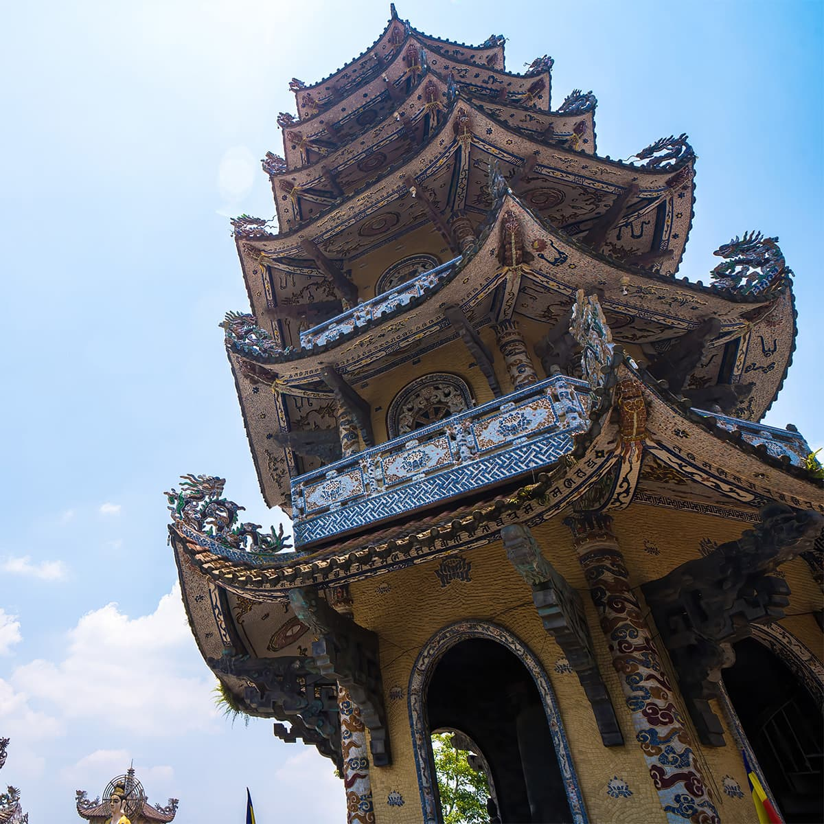 Колокольная башня Linh Tháp в Линь Фуок — семиярусная вертикаль с мозаичными карнизами и видом на окрестности Траймата, одна из самых высоких храмовых колоколен Вьетнама.