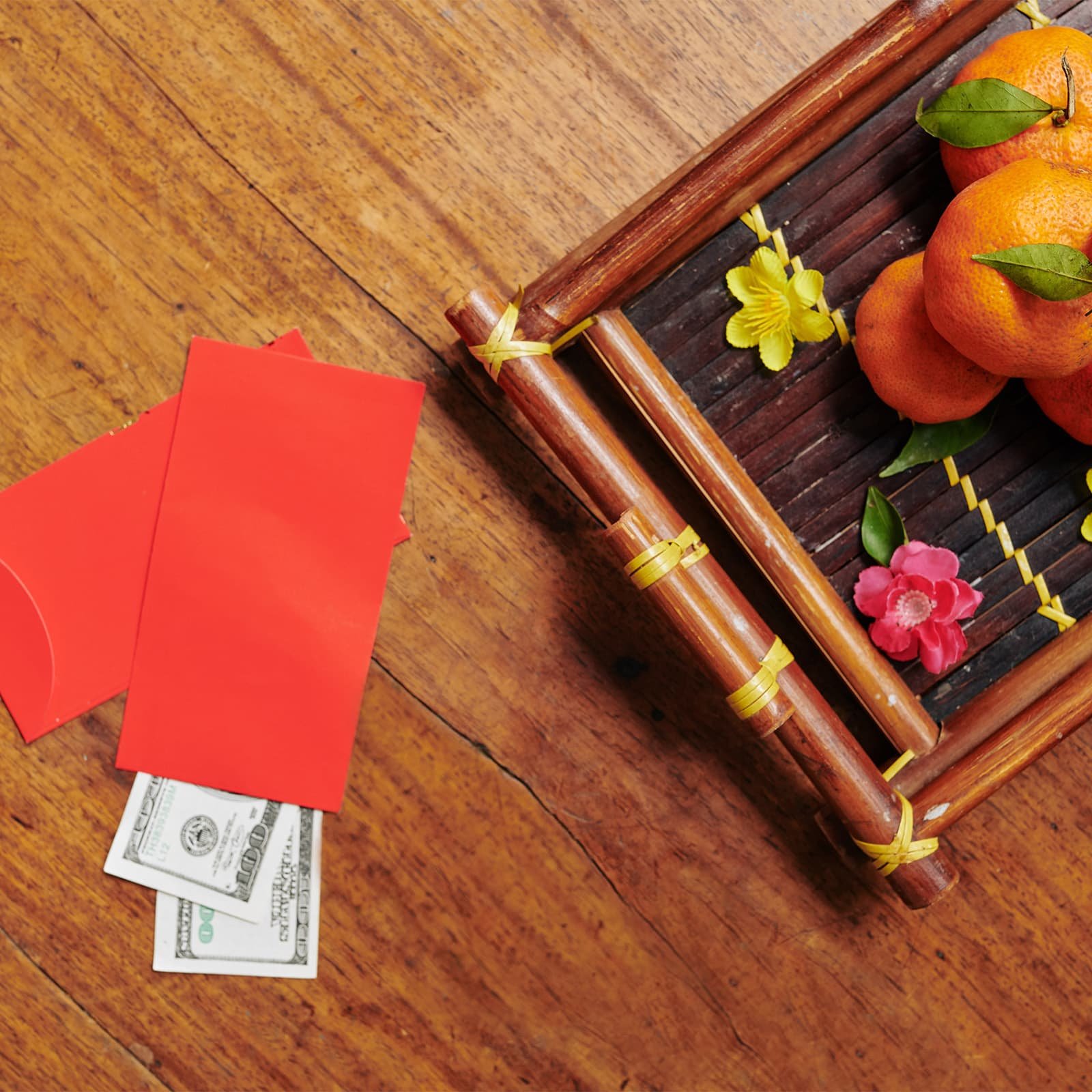 Подарок на Тет нередко собирают просто и красиво — красный конверт и фрукты как знак благополучия и уважения к семье.