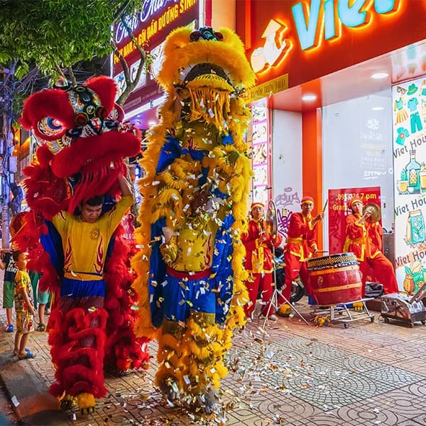 Персонаж Ông Địa в танце льва добавляет юмор и контакт со зрителями — он «ведёт» праздник и усиливает его дружелюбный характер.