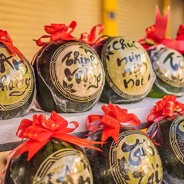 На тет-рынках можно увидеть арбузы с изображениями животных восточного календаря — сезонное ремесло становится частью праздничного декора.