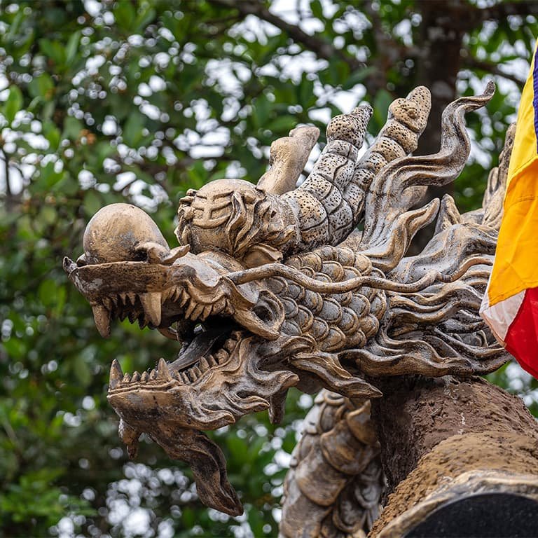 Каменные статуи драконов украшают пагоду Там Тай на Мраморных Горах Дананга