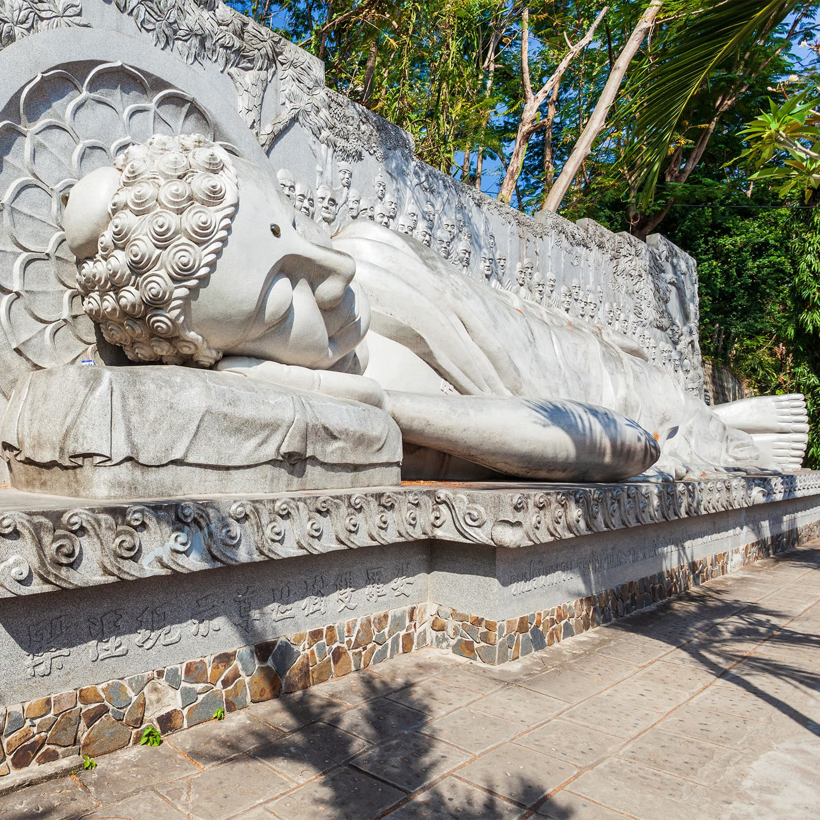 Белый Будда в Long Son Pagoda в Нячанге с мемориальными рельефами у основания — важная достопримечательность для тех, кто хочет увидеть религиозную историю и буддийское наследие города