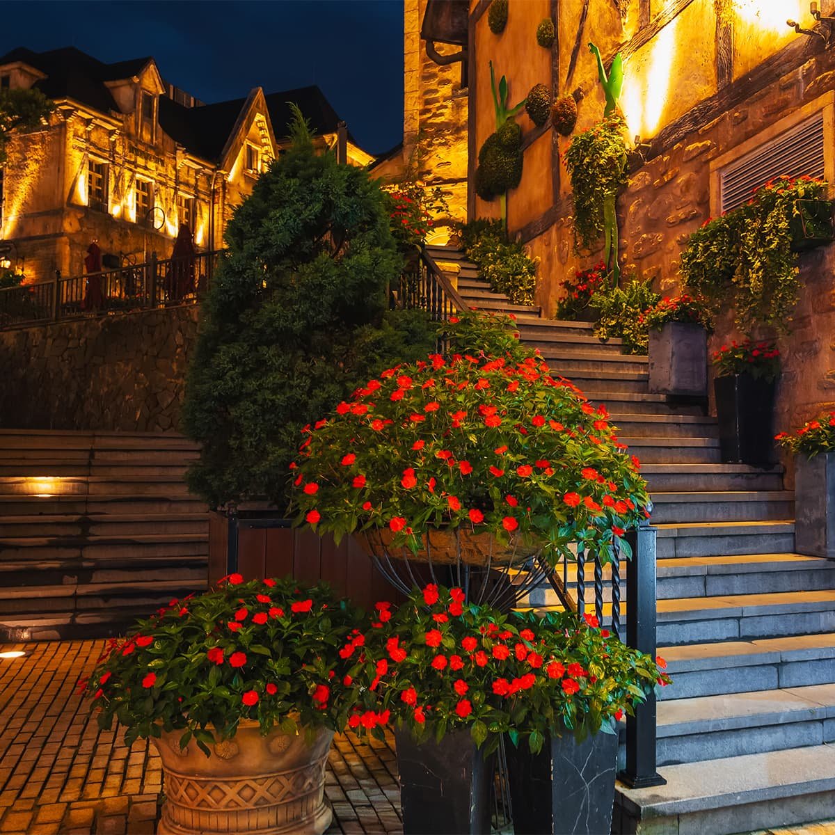 Вечерний тёплый свет освещает каменную лестницу в узких улочках Ба На Хиллс. Атмосфера напоминает старинные европейские города.