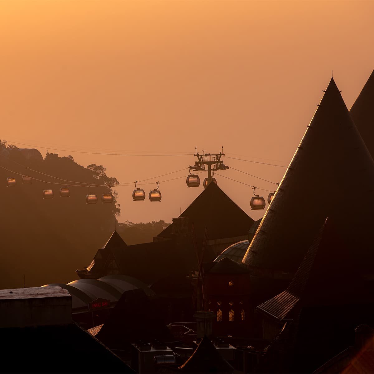 Фуникулер Ба На Хиллс в золотом свете заката. Экскурсия из Нячанга от TianaTours позволяет насладиться видами горного курорта Дананга и знаменитого Золотого моста.