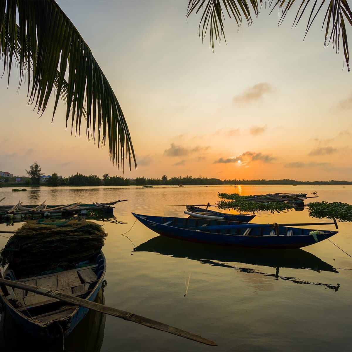Лодки на реке в лучах заката. Река Тху Бон — центральная часть исторического Хойана, где проходят прогулки и вечерние экскурсии.