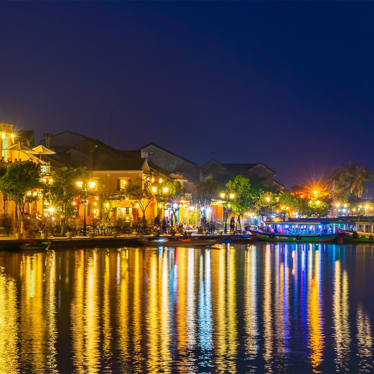 Вечерний Хойан у реки. Отражение фонарей и подсветки зданий создаёт неповторимую атмосферу старинного города во Вьетнаме.