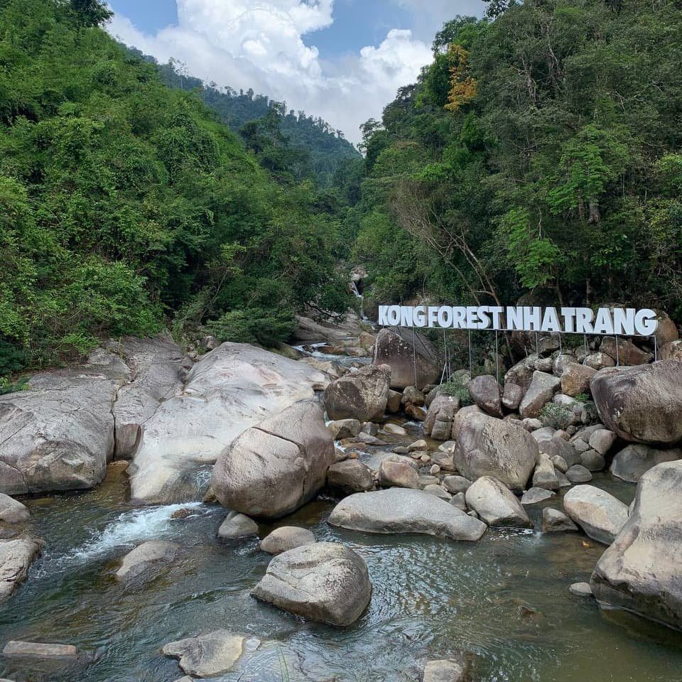 Небольшой водопад падает с каменной террасы в тени бамбука, наполняя пространство ровным шумом и прохладной влажностью